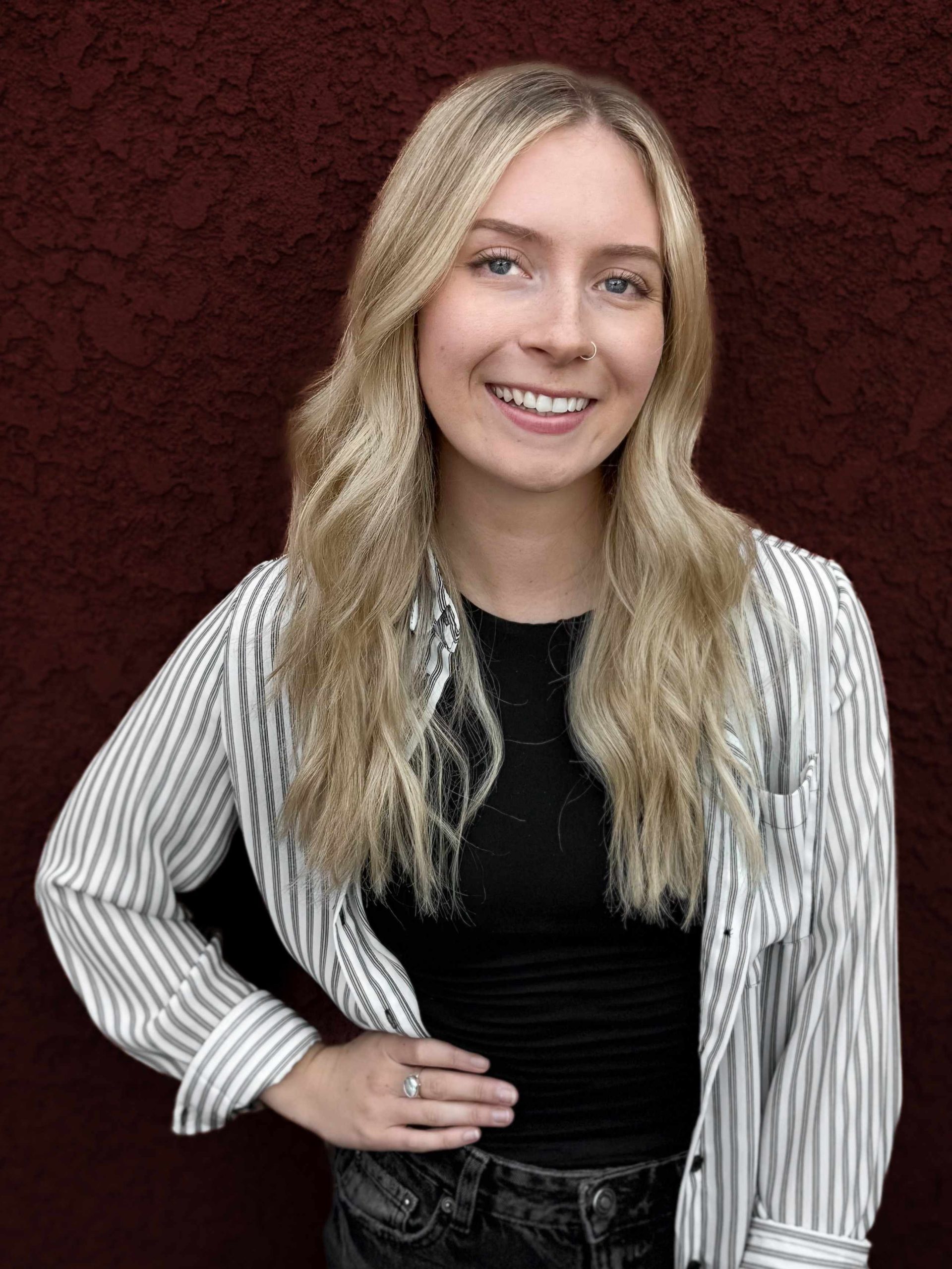 Kelly headshot against a red wall